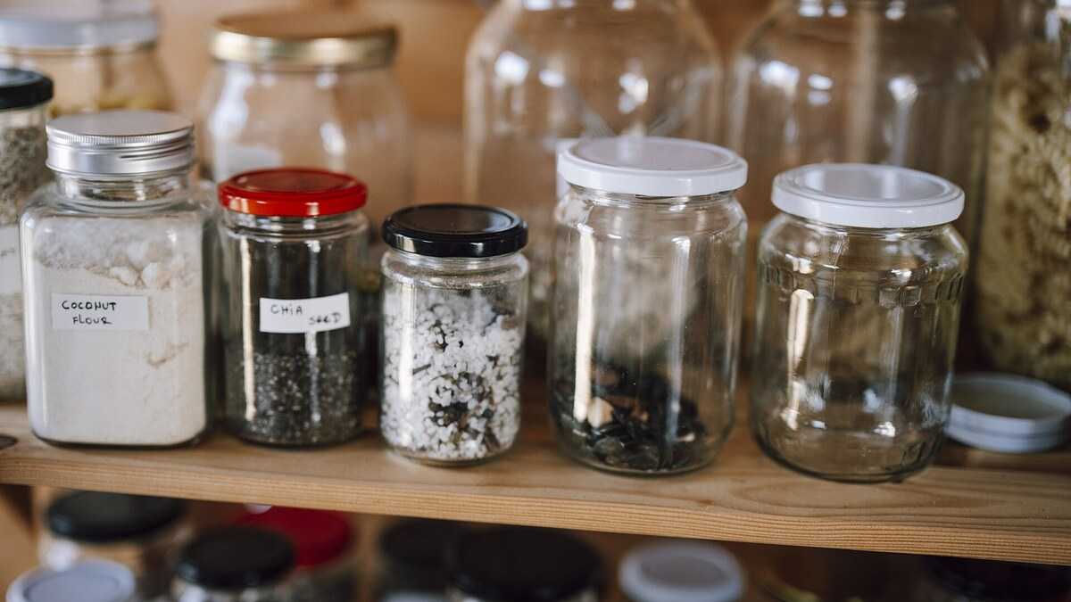 Placard de cuisine avec aliments secs rangés dans des bocaux hermétiques